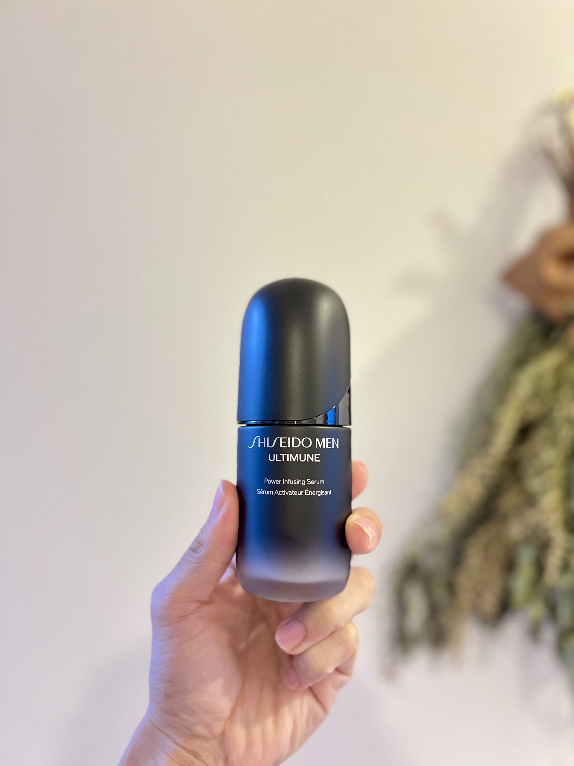手に持った資生堂メン（SHISEIDO MEN）のアルティミューン パワライジング セラムのボトル